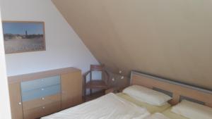 ein kleines Schlafzimmer mit einem Bett und einem Stuhl in der Unterkunft Ferienwohnung Buchenpark in Prerow