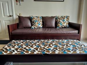 a brown couch with pillows on it in a living room at Apartamento en Tonsupa - Torresol Tropical in Tonsupa