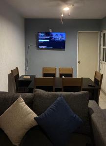 a living room with a couch and a television on a wall at Casa Marquesa 3 Habitaciones in Acapulco