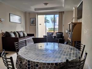 a living room with a table with chairs and a couch at Apartamento en Tonsupa - Torresol Tropical in Tonsupa