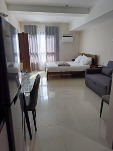 a hotel room with a bed and a couch and a table at Homey studio in jtower residences in Mandaue City