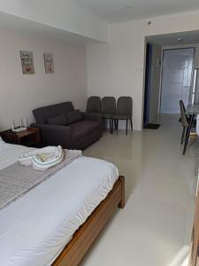 a living room with a bed and a couch at Homey studio in jtower residences in Mandaue City +1 photo