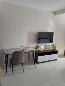a table with a chair and a television in a room at Homey studio in jtower residences in Mandaue City