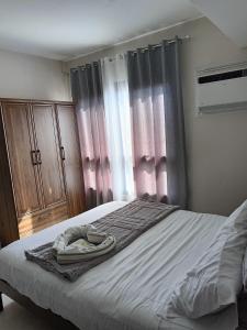 a bedroom with a bed with a dresser and curtains at Homey studio in jtower residences in Mandaue City