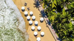 an aerial view of a beach with white umbrellas at InterContinental Nha Trang by IHG in Nha Trang