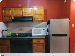 a kitchen with wooden cabinets and a white refrigerator at Habitaciones Comfort Centricas Durango in Durango