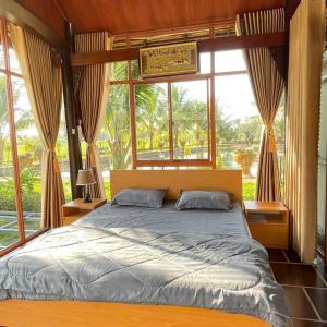 a bedroom with a large bed in front of a window at Melalueca tay ninh in Tây Ninh +106 photos