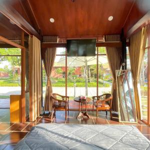 a bedroom with a tv and a table and chairs at Melalueca tay ninh in Tây Ninh