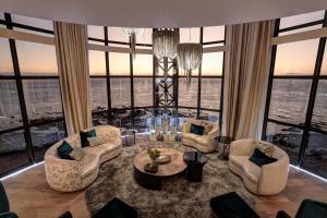 una sala de estar con sillas y una mesa en un edificio en Ocean View Penthouse en Strand