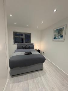 a bedroom with a large bed in a white room at Luxury modern guest house in Birmingham