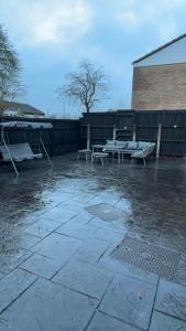 a patio with two benches and a table at Luxury modern guest house in Birmingham