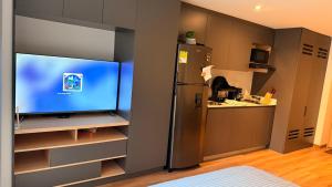 a kitchen with a refrigerator and a tv in a room at Teusaquillo Urban Loft in Bogotá