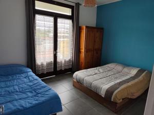 a bedroom with a bed and a window at La villa Madelon in Cilaos
