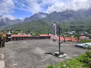 a closed umbrella on top of a building with mountains at La villa Madelon in Cilaos