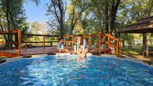 two children sitting on the edge of a swimming pool at Complejo Ebenezer in San Ignacio