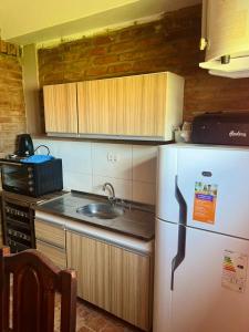 a kitchen with a white refrigerator and a sink at El Resguardo in San Luis +4 photos