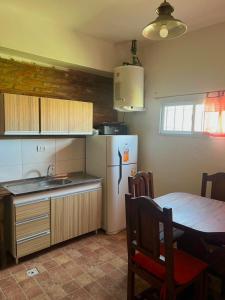 a kitchen with a table and a white refrigerator at El Resguardo in San Luis
