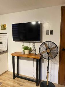 a flat screen tv on a table with a fan at Benido Farm - A Secret Haven in San Jose