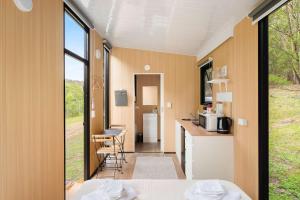 a room with a counter and a kitchen with windows at Wombat Hideaway by Tiny Away in Laguna