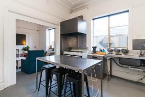 a kitchen with a table with stools in it at Manly Beach Guesthouse in Sydney +59 photos