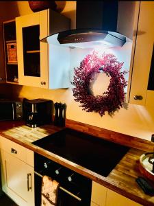 a kitchen with a sink and a wreath on a counter at Olive Tree Cottage in Golcar +5 photos