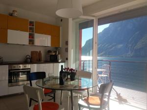 アッバディーア・ラリアーナにあるa...fior di lagoのキッチン、ダイニングルーム(ガラスのテーブル、椅子付)