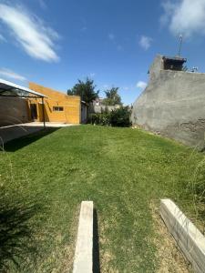 a grassy yard with a building in the background at Alquiler temporal in Plottier