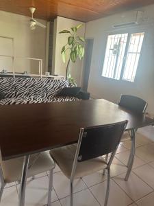 a dining room table with two chairs and a plant at Alquiler temporal in Plottier