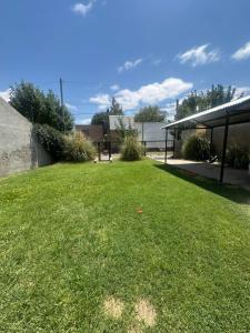 a grassy yard with a bench in the background at Alquiler temporal in Plottier