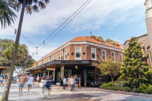 a group of people walking down a street in front of a building at Manly Beach Guesthouse in Sydney