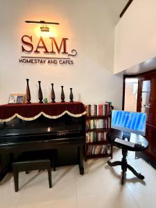 a room with a piano and a desk with a laptop at SAM Homestay and Cafés in Thôn An Hòa