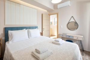 a bedroom with a white bed with towels on it at Erato by Vintage Travel in Tsoukalades +33 photos