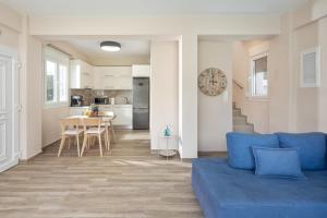 a living room with a blue couch and a kitchen at Erato by Vintage Travel in Tsoukalades