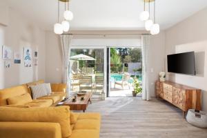 a living room with a couch and a tv at Klio by Vintage Travel in Agios Georgios