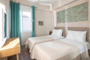 two beds in a small room with a window at Klio by Vintage Travel in Agios Georgios +35 photos
