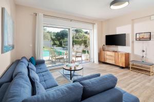 a living room with a blue couch and a tv at Erato by Vintage Travel in Tsoukalades