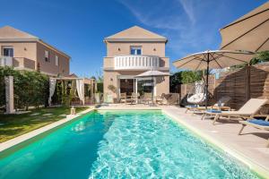 a swimming pool in front of a house at Klio by Vintage Travel in Agios Georgios