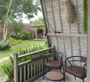 two chairs and a table on a porch at Natuna Garden Villa in Ranai