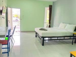 a bedroom with a bed and a table and a table at โรงแรมสิริพรชัย 2 in Takua Pa