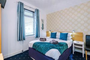 a bedroom with a large bed with blue pillows at Blackpool Lodge in Blackpool