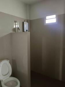 a bathroom with a toilet with a phone on the wall at โรงแรมสิริพรชัย 2 in Takua Pa