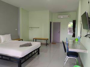 a bedroom with a bed and a desk and a chair at โรงแรมสิริพรชัย 2 in Takua Pa