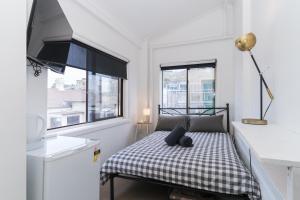 a bedroom with a bed with a checkered blanket at Manly Beach Guesthouse in Sydney