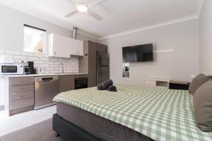 a bedroom with a bed with a green and white checkered blanket at Manly Beach Guesthouse in Sydney