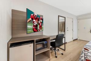 a room with a desk with a tv on it at Red Roof Inn Buffalo - Niagara Airport in Williamsville