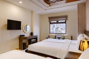 a hotel room with two beds and a television at Boss Palace Hotel in Ho Chi Minh City +75 photos