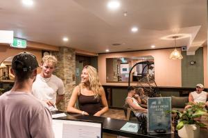 a group of people standing around a counter in a restaurant at Aquarius Backpackers Resort in Byron Bay +71 photos