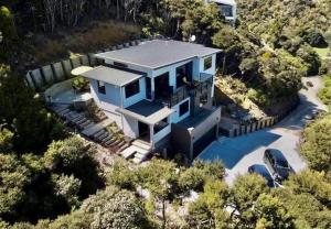 an aerial view of a blue house with a car at W91 Stylish, Modern, Beach view in Tutukaka