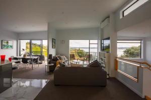 a living room with a couch and a table at W91 Stylish, Modern, Beach view in Tutukaka +20 photos
