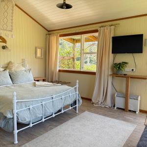 a bedroom with a large bed and a window at Wisteria Way in Opononi